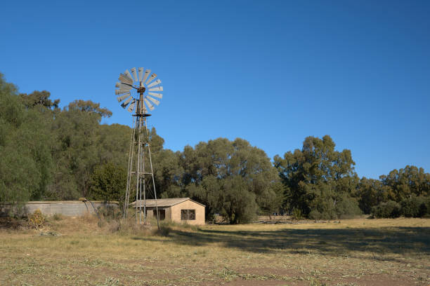istock Rural landscape windmill barn trees grass and blue sky 1333087971