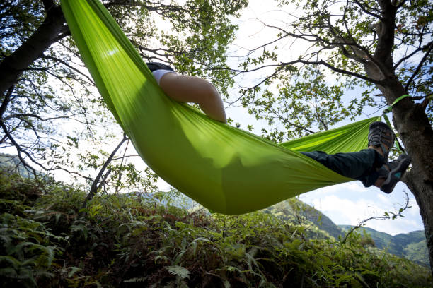 istock Relaxing in hammock hand using smartphone in tropical rainforest 1333089033