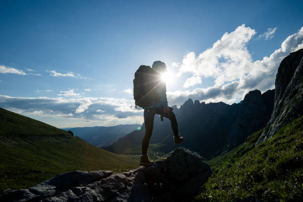 istock Successful woman backpacker hiking on sunset alpine mountain peak 1333092705