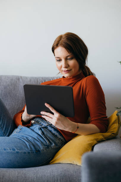 istock Smiling Woman Using Digital Tablet at Home 1333092733