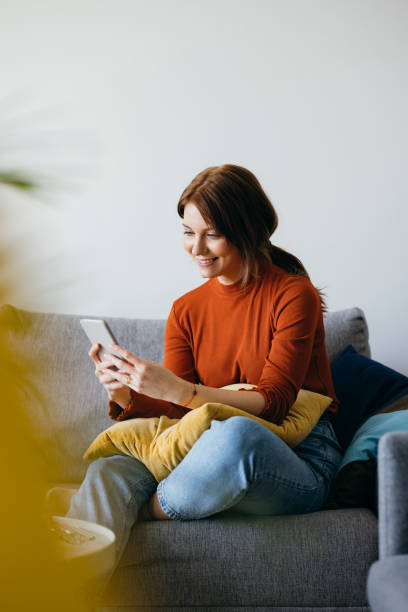 istock Cheerful Woman Using Mobile Phone at Home 1333092749