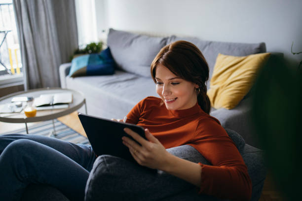 Smiling Young Woman Using Digital Tablet at Home