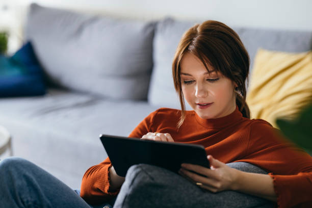 istock Beautiful Young Woman Using Digital Tablet at Home 1333092801