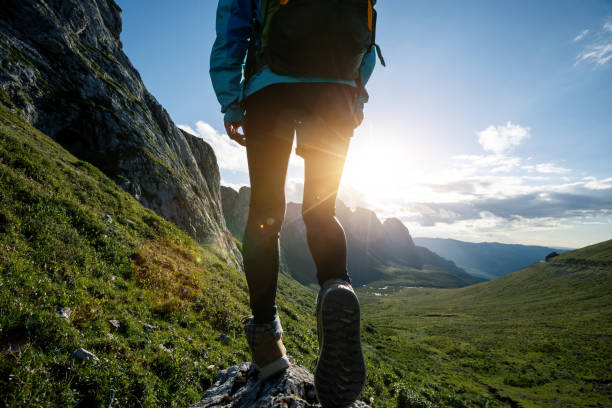 istock Successful woman backpacker hiking on sunset alpine mountain peak 1333092864