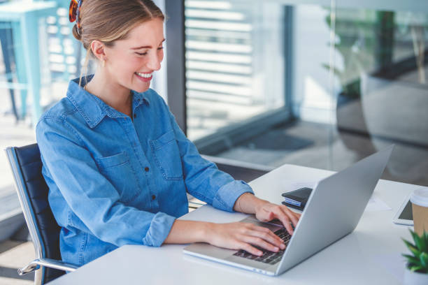 istock Young business woman working on a laptop computer in an office. 1333096366