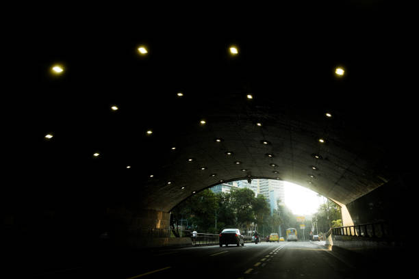 Inside the tunnel with dark lights and few vehicles.