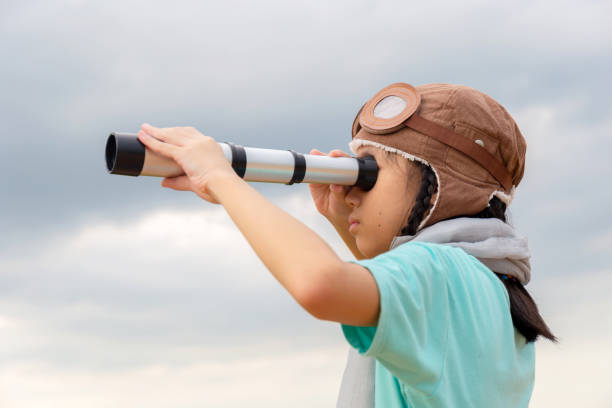 portrait of asian child girl looking in spyglass, happy kid playing outdoors - ongebruikelijk stockfoto's en -beelden