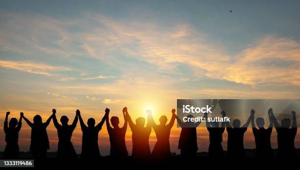 Silhouette Of Group Business Team Making High Hands Over Head In Sunset Sky Stock Photo - Download Image Now