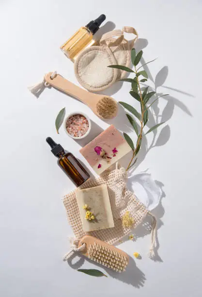 Photo of Eco-friendly and zero waste concept beauty spa  with natural cosmetic products: soap, sponges, oil  and massage brushes, mineral salt on white background.  Top view and copy space