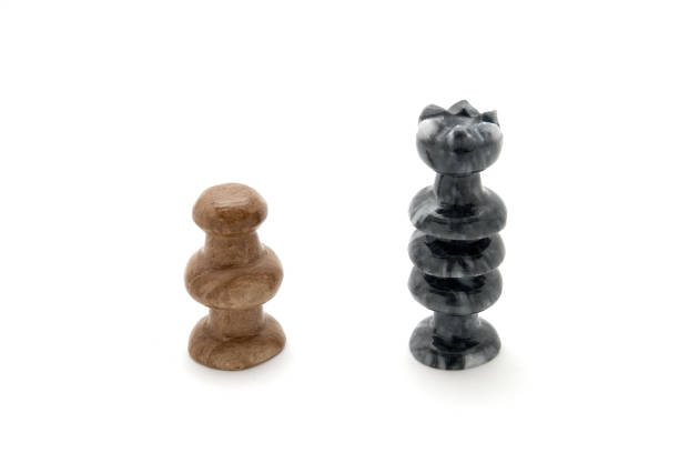 Two chess pieces, white pawn and black queen face off