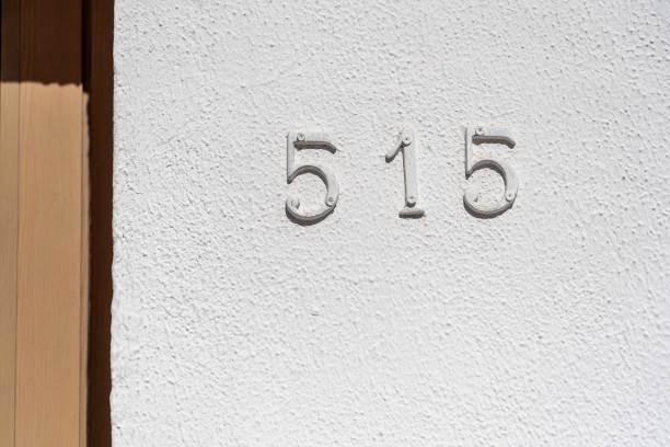istock Metal house number 515 on a white stucco wall background 1333129361