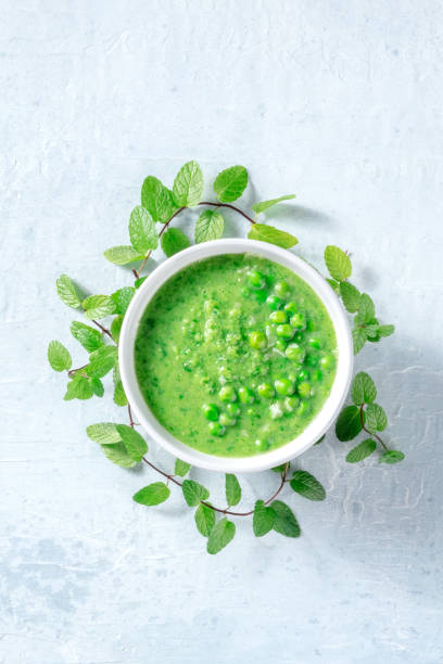 sopa verde vegana com hortelã em um prato profundo, tiro de cima - vegan pea soup - fotografias e filmes do acervo