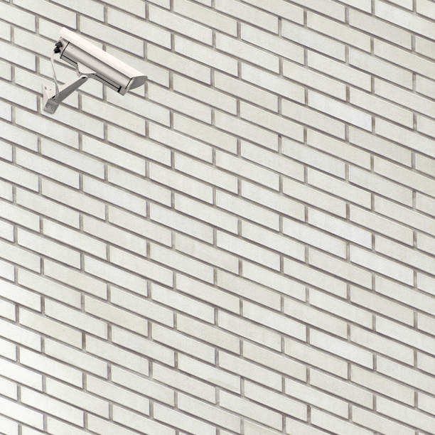 istock Facility video surveillance cctv camera 24 hour security control TV watch monitoring, system concept, white grey fine brick wall perspective pattern closeup, textured copy space background, large detailed light gray taupe horizontal brickwork texture 1333132795
