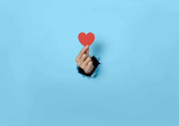 istock Woman hand holding heart on blue background. 1333137045