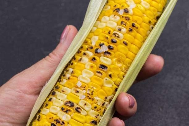istock Grilled corn cob in woman's hand. 1333137358