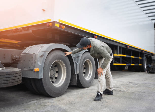 アジアのトラック運転手はトレーラートラックの車輪とタイヤをチェックしています。点検の維持および安全運転。 - flatbed truck truck truck driver heavy ストックフォトと画像