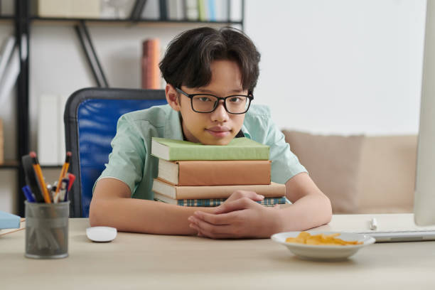 istock Teenage Boy Leaning on Books Stack 1333149584