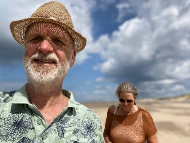 네덜란드 해안에서 커플 - women wading sun hat summer 뉴스 사진 이미지