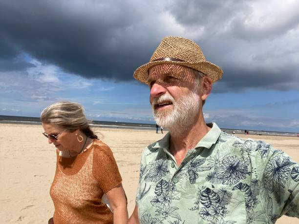 coppia sulla costa olandese - women wading sun hat summer foto e immagini stock