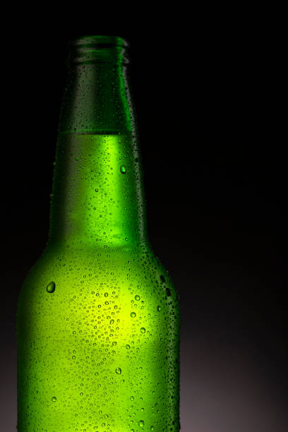 istock Ice Cold  Green Bottle Covered with ice and water drops - condensation. Blank for drink beverage product design mock-up.  Standing on  dark - black background. 1333150934