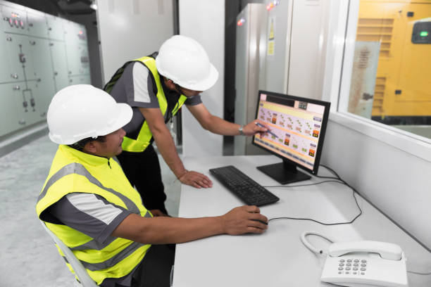 engenharia elétrica com inspetor durante treinamento e gravação em operação de energia na usina para processo de produção - control panel factory control machine - fotografias e filmes do acervo