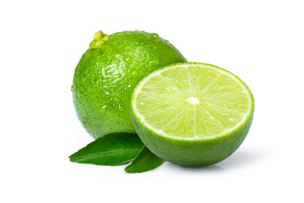 lima cítrica verde y cortada en rodajas a medias aislada sobre blanco - limones verdes fotografías e imágenes de stock