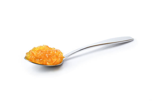 Orange Jelly marmalade jam in stainless spoon isolated on white background. Clipping path. Jelly marmalade jam in stainless spoon isolated on white background. Clipping path.