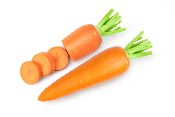 Fresh organic carrot with cut slices isolated on white background. Top view. Flat lay.