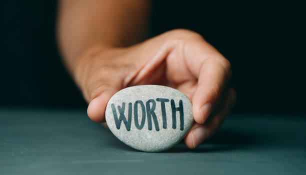 istock man showing a stone with the text worth 1333157043