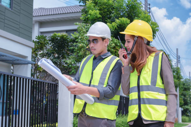 istock Asian engineers holding blueprint in their hands discussing plan with house inspectors to prepare for delivery to customers. 1333158111