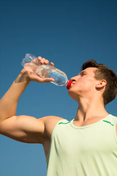 istock Athlete in green tshirt on blue sky. 1333158336