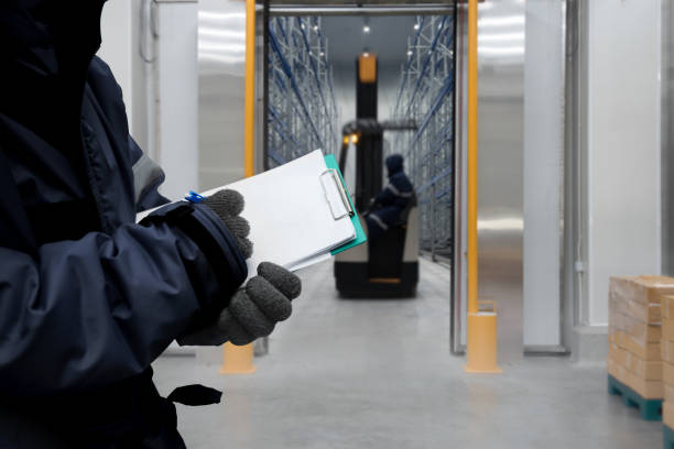 Hand of worker with clipboard checking goods in freezing room or warehouse Hand of worker with clipboard checking goods in freezing room or warehouse cold storage stock pictures, royalty-free photos & images