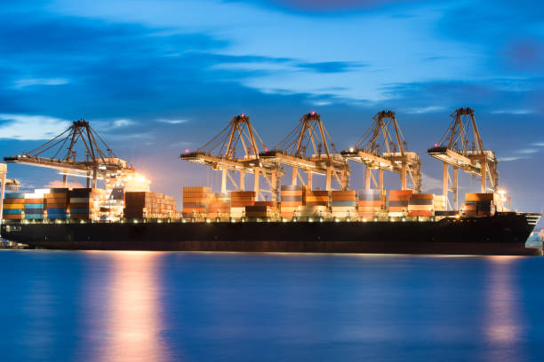 istock Container Cargo freight ship Import-Export with gantry crane bridge in shipyard at dusk time for logistics background 1333159192