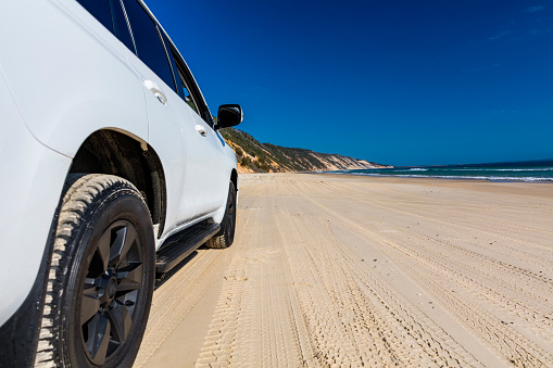 Off road vehicle on a colourful pristine beach, Queensland, Australian