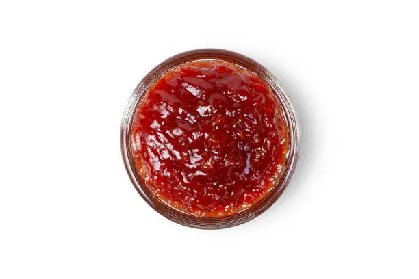 Glass jar of red jam isolated on white background. Clipping path. Top view. Flat lay.