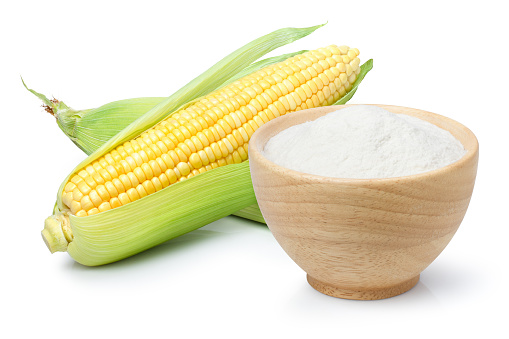Corn flour in wooden bowl and fresh sweet corn isolated on white background.