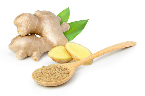 Ginger powder in wooden bowl and fresh ginger rhizome with cut sliced isolated on white background.