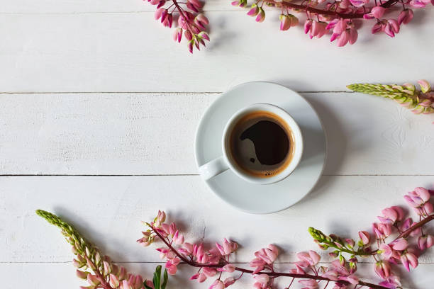 tazza di caffè con piattino e fiori di lupino rosa a bordo di sfondo bianco in legno. posizionare per il testo e il prodotto, lo spazio di copia, la vista dall'alto, la flatlay. - espresso table coffee cafe foto e immagini stock