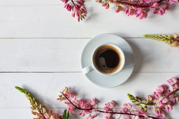 coffee cup with saucer and pink lupine flowers on board white wooden background. place for your text and product, copy space, top view, flatlay. - espresso table coffee cafe imagens e fotografias de stock