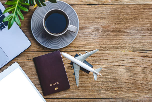 istock Mockup image of blank screen digital tablet, passport, laptop computer, airplane and cup of coffee design template isolated on wooden table background. 1333163659