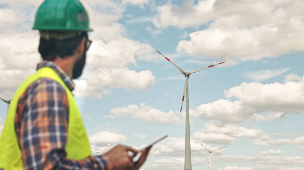 istock Electric engineer inspecting windmill turbine with tablet 1333163767