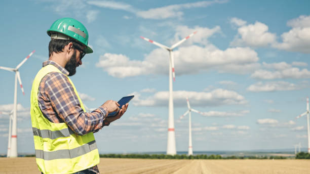 istock Electric engineer inspecting windmill turbine with tablet 1333163778