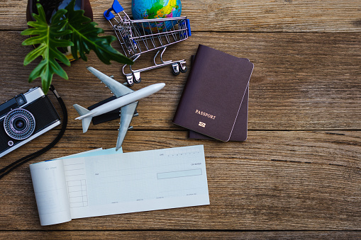 Cheque book, laptop computer, passport, global model mock up isolated on wooden table background. Business technology and air travel overseas concept.