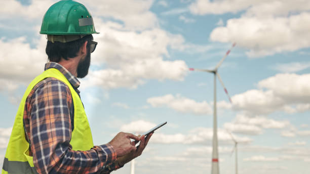 istock Electric engineer inspecting windmill turbine with tablet 1333163826