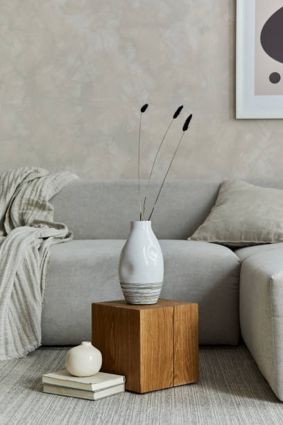 istock Creative composition of stylish japandi living room with mock up poster frame, grey sofa, wooden cubes, design vases and small personal accessories. Creative wall and parquet floor. Details. Template. 1333165123