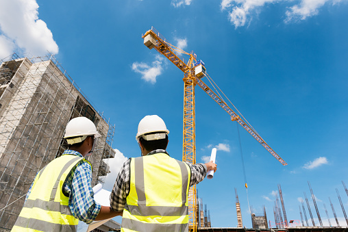 Los ingenieros de construcción debaten con los arquitectos en el sitio de construcción o el sitio de construcción del edificio de gran altura photo