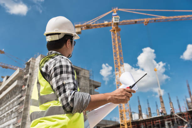 istock Civil engineer checking work with  construction drawing at building site of highrise building 1333165159