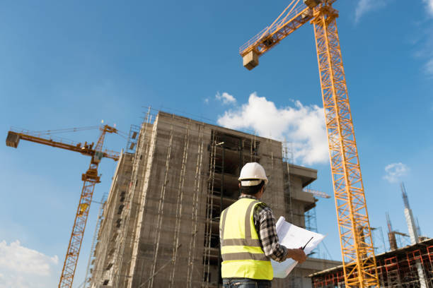 istock Civil engineer checking work with  construction drawing at building site of highrise building 1333165170