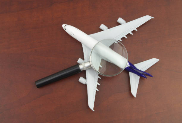 istock Checking tickets price. Airplane model under magnifying glass. 1333166931