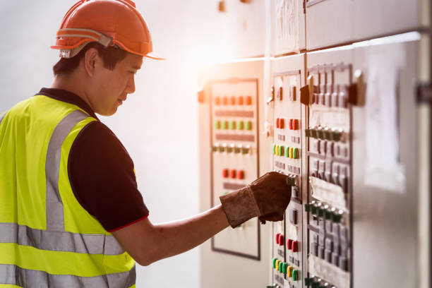 electricista buscando panel de control en el lugar de trabajo. el ingeniero trabaja en el concepto de trabajos de control de calidad industrial. - maintenance engineer industry asian ethnicity technology fotografías e imágenes de stock